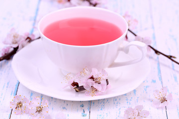 Fragrant tea with flowering branches on wooden table close-up