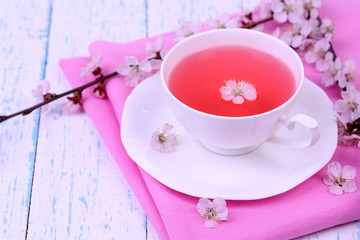Fragrant tea with flowering branches on wooden table close-up