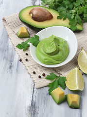 Fresh guacamole in bowl on wooden table