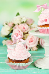 Tasty cup cakes with cream on blue wooden table