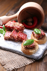 Composition with knife,  tasty sandwiches with salami sausage,