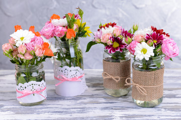 Beautiful bouquet of bright flowers in jars