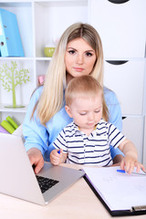 Pretty woman with baby working at home