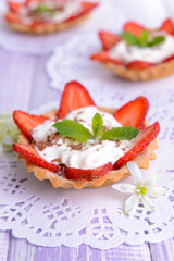 Tasty tartlets with strawberries on table close-up