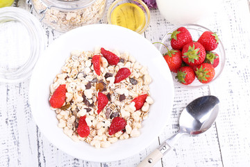 Healthy cereal with strawberry and milk on wooden table
