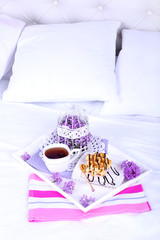 Light breakfast and beautiful bouquet on bed