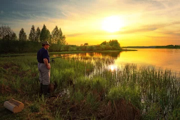 Photo sur Plexiglas Anti-reflet Pêcher Fisherman on the lake on the background of colorful sunset