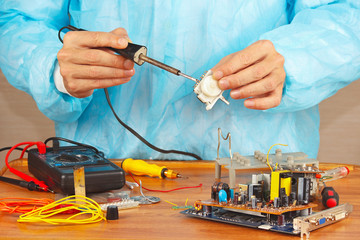 Serviceman solder electronic hardware in the service workshop