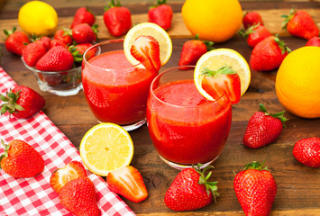 Strawberry smoothies with fresh fruits on wooden background