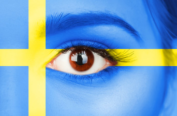 Human face painted with flag of Sweden