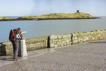 man looking to Dalkey island by binoculars