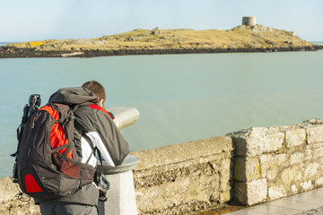 man looking to Dalkey island by binoculars