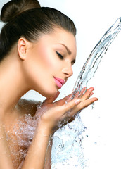 Beautiful model woman with splashes of water in her hands