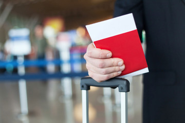 close up of passport and ticket in hand in airport