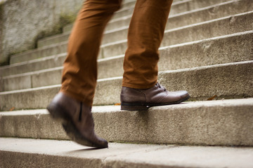 Walking upstairs: close-up view of man's leather shoes