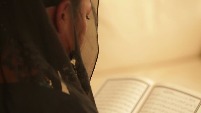 Muslim woman praying and reading koran