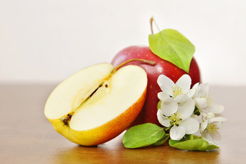 Ripe red apple fruit and apple flower on the wooden board