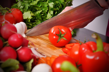 hands cutting tomato