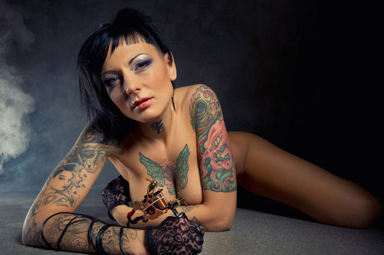 Beautiful woman with many tattoos indoors