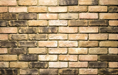 Vibrant yellow brick wall as a background image with vignette