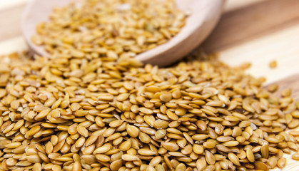 Golden flax seed spilled on table