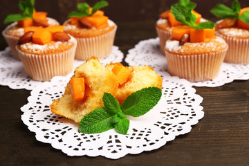 Tasty pumpkin muffins on wooden table