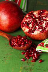 Ripe pomegranates on color wooden background