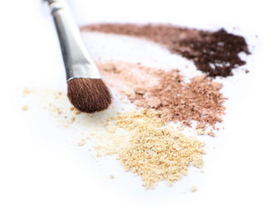 Crushed eyeshadow and professional make-up brush isolated