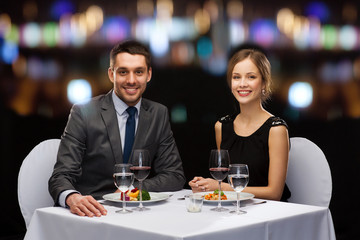 smiling couple eating main course at restaurant