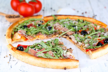 Pizza with arugula on color wooden background