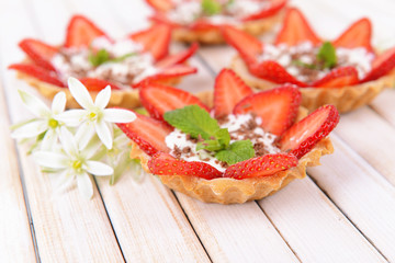 Tasty tartlets with strawberries on table close-up