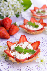 Tasty tartlets with strawberries on table close-up