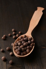 Spice pepper in spoon on wooden background