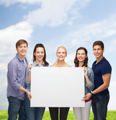 group of standing students with blank white board