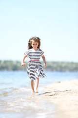 Fototapeta na wymiar Beautiful little girl on the beach