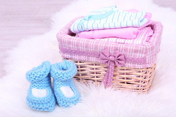 Baby clothes in basket on floor in room