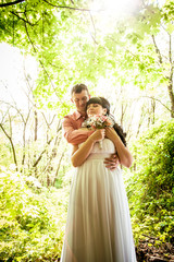 portrait of groom hugging bride under tree at park