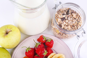 Healthy cereal with milk and fruits close up