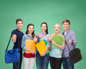 Fototapeta na wymiar group of smiling students showing thumbs up