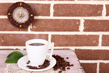 Still life cup of coffee and clock, on brick wall background