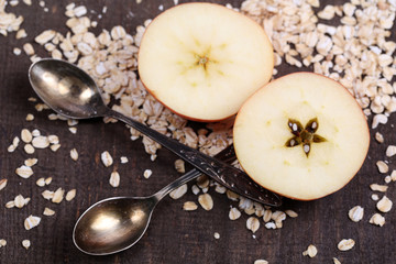 Apple with oatmeal and vintage spoons,