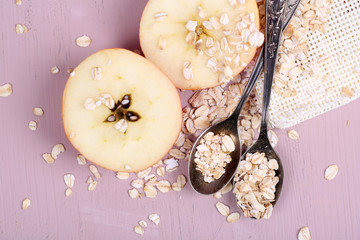 Apple with oatmeal and vintage spoons,