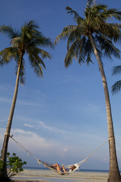 woman relaxing on the hammock on a tropical beach .