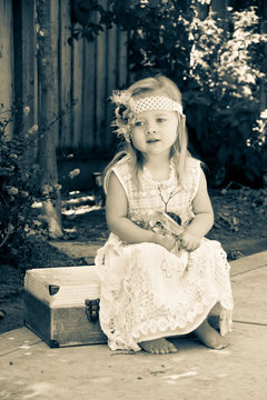 Vintage Little girl sittig on suitcase