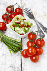 Bowl of fresh salad on wooden table