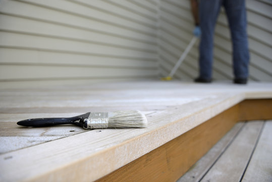 Closeup of Paint Brush with Worker in Background