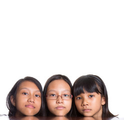 Teenage sisters with face reflection on wooden table surface