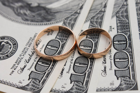 Wedding rings on the background of money - Powered by Adobe