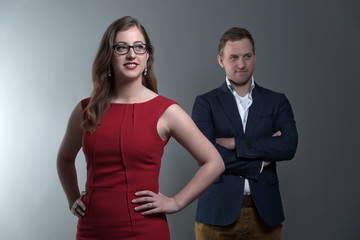 Fashion couple wearing a red dress and blue jacket. She is weari