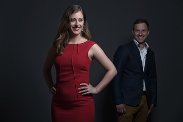 Fashion couple wearing a red dress and blue jacket. Young man an